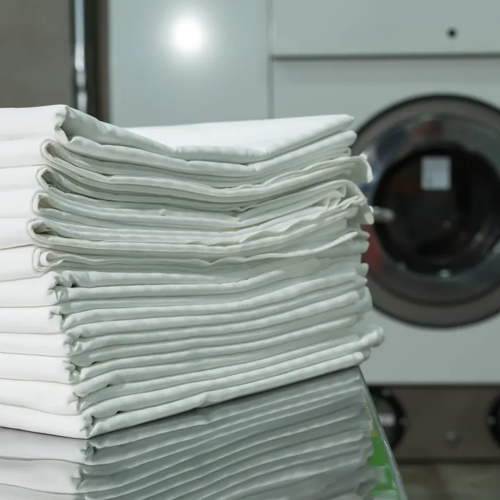 Linge plié devant une machine à laver professionnelle